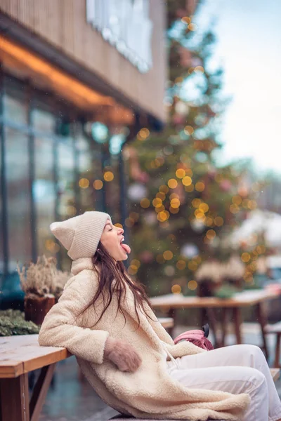 Gelukkig meisje in de buurt van dennenboom tak in de sneeuw voor het nieuwe jaar. — Stockfoto