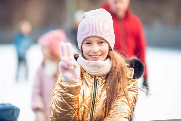 Adorable niña patinando en la pista de hielo —  Fotos de Stock