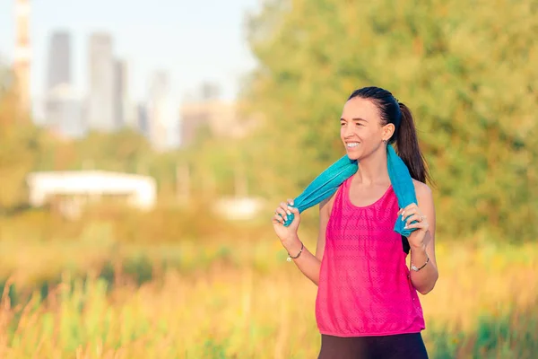 Joven mujer sonriente haciendo ejercicios deportivos al aire libre — Foto de Stock