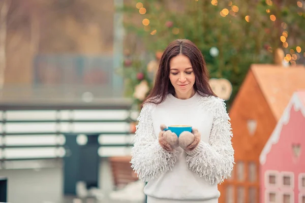 Les mains féminines tiennent une tasse de café blanc avec des guimauves blanches et roses — Photo