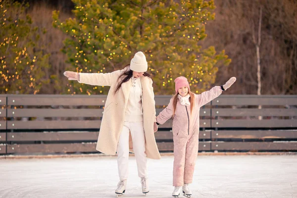 Aranyos kislány anyja korcsolyázás ice rink — Stock Fotó