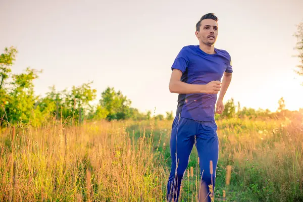 Joven deportivo haciendo ejercicios deportivos al aire libre en el parque — Foto de Stock