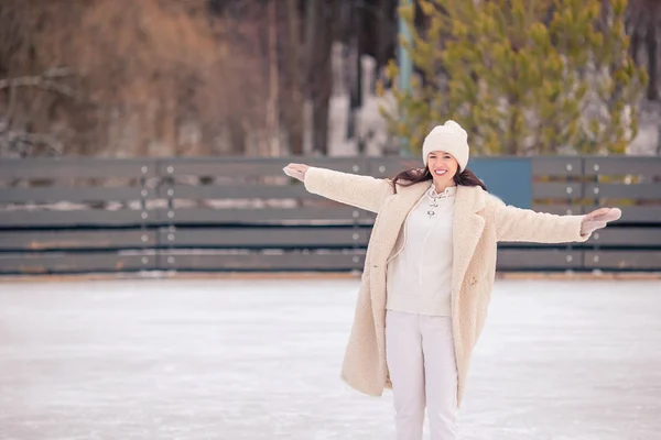 Sonriente niña patinando en pista de hielo al aire libre —  Fotos de Stock