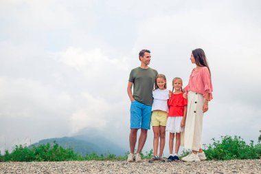 Sisin arkasındaki dağlarda güzel mutlu bir aile.