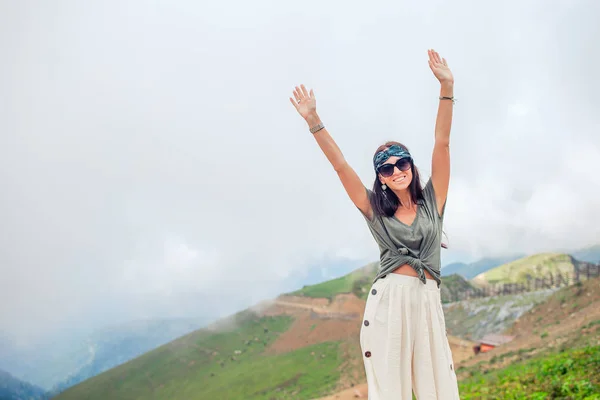 Beautiful happy young woman in mountains in the background of fog — Stock Photo, Image