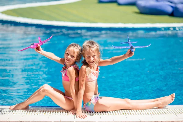 Beautiful little girls having fun near an outdoor pool — Stock Photo, Image