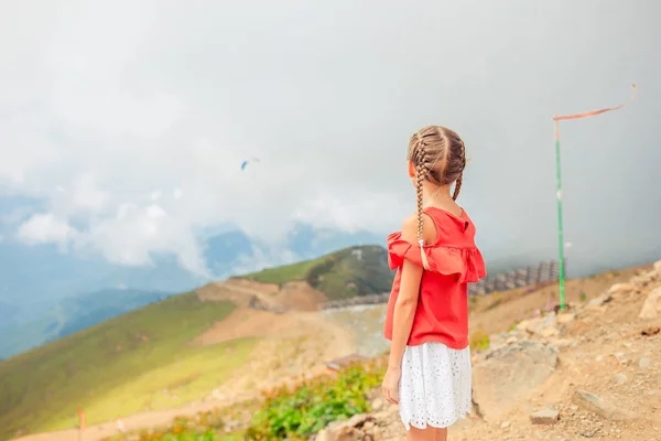 Beautiful happy little girl in mountains in the background of fog — Stock Photo, Image