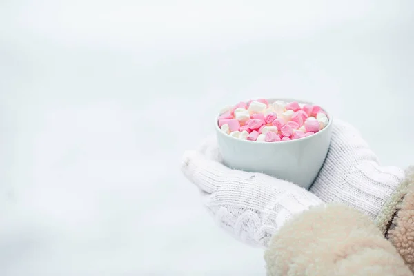 Female hands holdink white cup of coffee with white and pink marshmallows — Stock Photo, Image