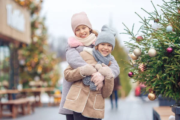 Aranyos lányok korcsolyázás ice rink kint a téli hó nap — Stock Fotó