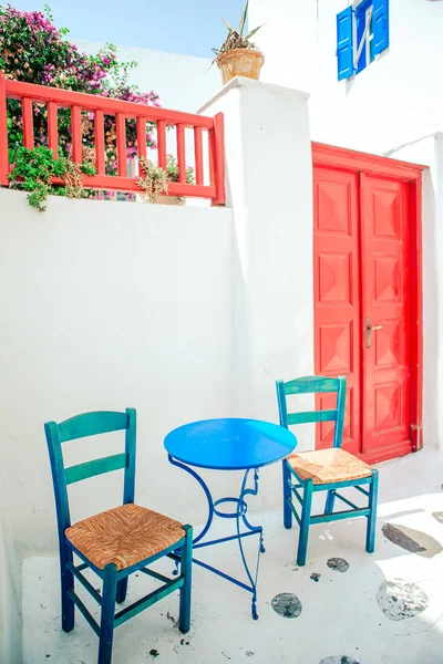 Modré židle a stůl na ulici typické řecké tradiční vesnice s domy na ostrově Mykonos, Řecko, Evropa — Stock fotografie