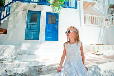 Tipik Yunan köyünün eski sokağında sevimli küçük bir kız.