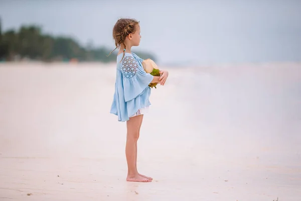 Niña adorable con coco grande en la playa de arena blanca —  Fotos de Stock