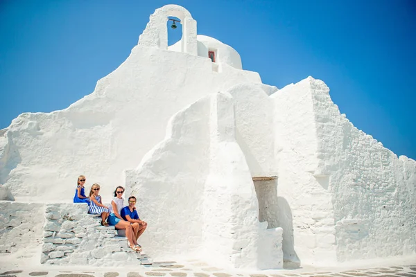 Family of four on the stairs of Paraportiani church on Mykonos — Stock Photo, Image