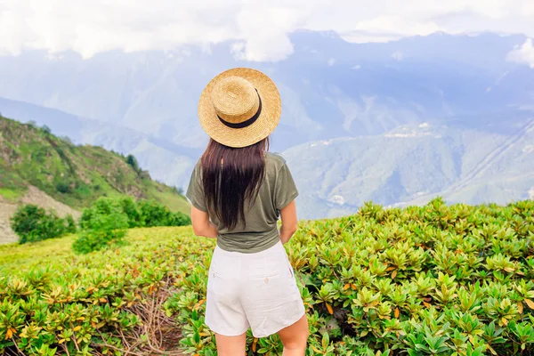 Mulher jovem feliz bonita em montanhas no fundo do nevoeiro — Fotografia de Stock