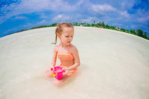 Sevimli küçük kız sırasında tatil tropikal plaj oyuncakları ile oynarken — Stok fotoğraf