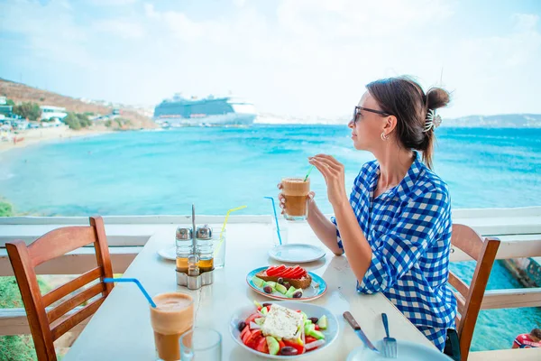 Kvinna dricka varmt kaffe på luxury hotellterrassen med havsutsikt resort restaurang. — Stockfoto