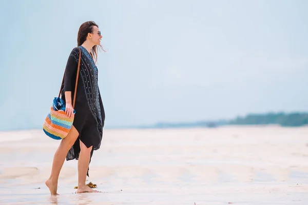 Joven hermosa mujer divirtiéndose en la orilla del mar tropical. Chica feliz caminando en la playa tropical de arena blanca — Foto de Stock