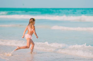 Mutlu küçük kız Karayipler tatil sırasında kumsalda yürüyüş