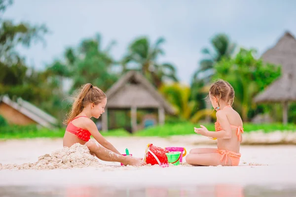 Duas crianças fazendo castelo de areia e se divertindo na praia tropical — Fotografia de Stock