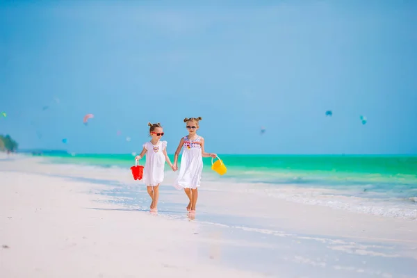 Little happy funny girls have a lot of fun at tropical beach playing together. Sunny day with rain in the sea — Stock Photo, Image