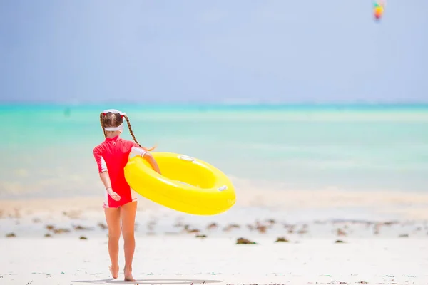 Criança feliz com círculo de borracha inflável se divertindo na praia — Fotografia de Stock