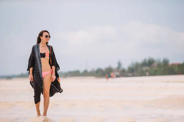 Jovem mulher bonita se divertindo na costa tropical. Menina feliz andando na areia branca praia tropical — Fotografia de Stock