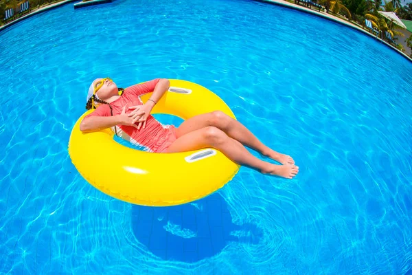 Şişme lastik çemberli mutlu çocuk sahilde eğleniyor.