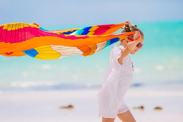 Feliz niña divirtiéndose corriendo con pareo en la playa tropical blanca —  Fotos de Stock