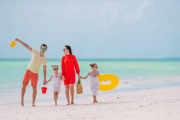 Lycklig vackra familj av fyra på stranden — Stockfoto