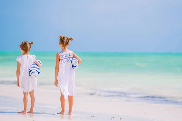 Adorable little girls with beach towels on white tropical beach — Stock Photo, Image