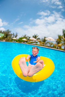 Şişme lastik çemberli mutlu çocuk sahilde eğleniyor.