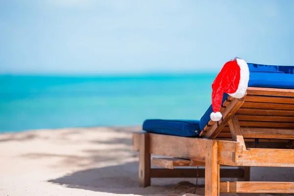 Sun loungers with Santa Hat at at beautiful tropical beach with white sand and turquoise water. Перфектные рождественские каникулы — стоковое фото