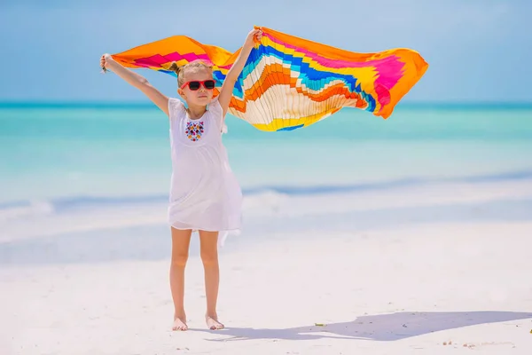 Glad liten tjej att ha kul kör med sarong på tropiska stranden — Stockfoto