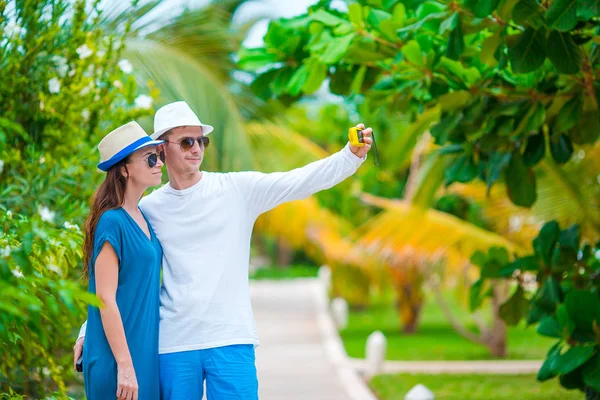 Balayı tatilinde beyaz sahilde fotoğraf çeken mutlu çift. — Stok fotoğraf