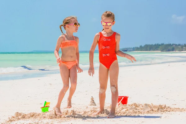 Duas meninas felizes se divertem muito na praia tropical jogando juntas — Fotografia de Stock