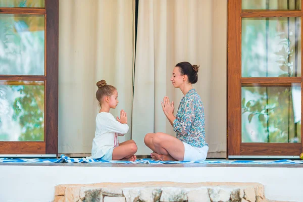 Happy young family meditating on the terrace — Stock Photo, Image