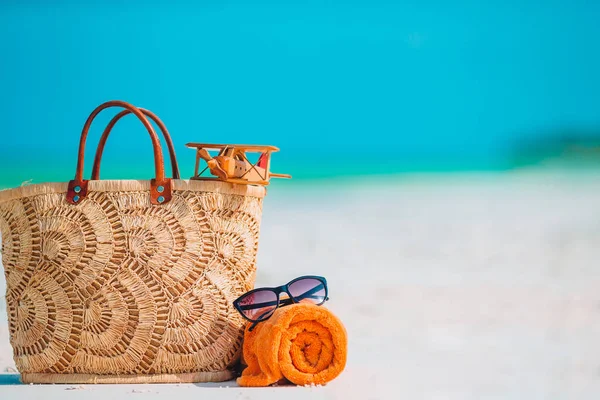 Plážové doplňky - tašky, slaměný klobouk, sluneční brýle na bílé pláži — Stock fotografie