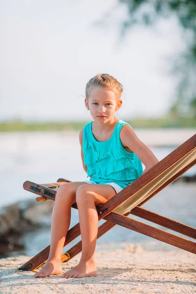 Adorável menina relaxante na cadeira de praia — Fotografia de Stock