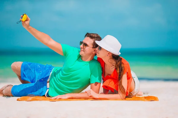 Pareja feliz tomando una foto de uno mismo en una playa en vacaciones —  Fotos de Stock