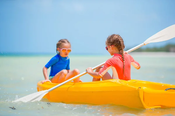 Little adorable girls enjoying kayaking on yellow kayak — Stock Photo, Image