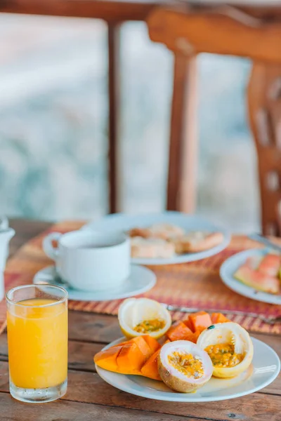 Sabrosas frutas exóticas - fruta de la pasión madura, mango en el desayuno en restaraunt al aire libre — Foto de Stock