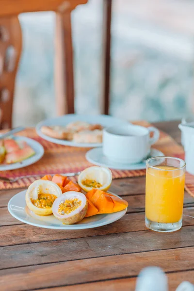 Tasty exotic fruits - ripe passion fruit, mango on breakfast at outdoor restaraunt — Stock Photo, Image