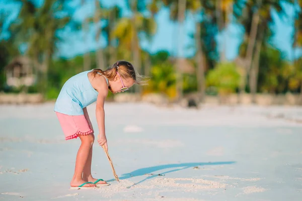 Little girl at tropical white beach making sand castle — Stock Photo, Image