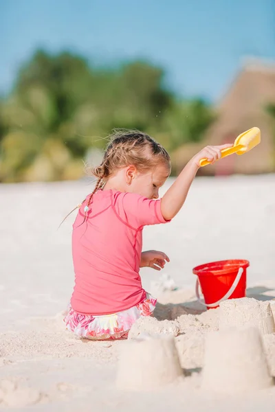 Klein meisje op tropisch wit strand maken zand kasteel — Stockfoto