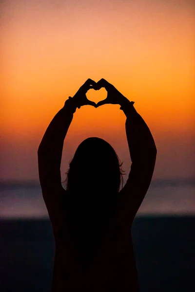 Silueta de corazón hecha a mano por los niños al atardecer —  Fotos de Stock