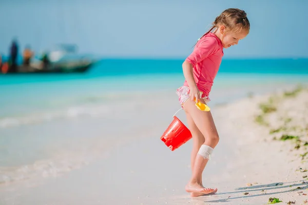 Schattig klein meisje spelen met strand speelgoed op wit tropisch strand — Stockfoto