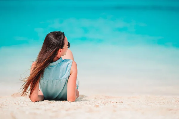 Donna sdraiata sulla spiaggia godendo di vacanze estive guardando il mare — Foto Stock