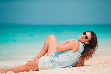 Plajda uzanan kadın yaz tatilinin tadını çıkarıyor ve denize bakıyor.