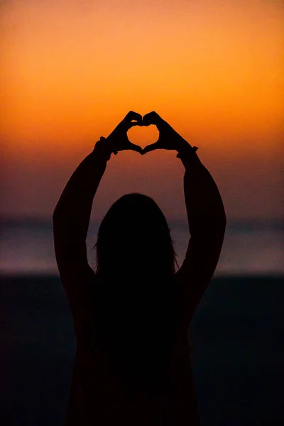 Silhueta de coração feita por crianças mão ao pôr do sol — Fotografia de Stock