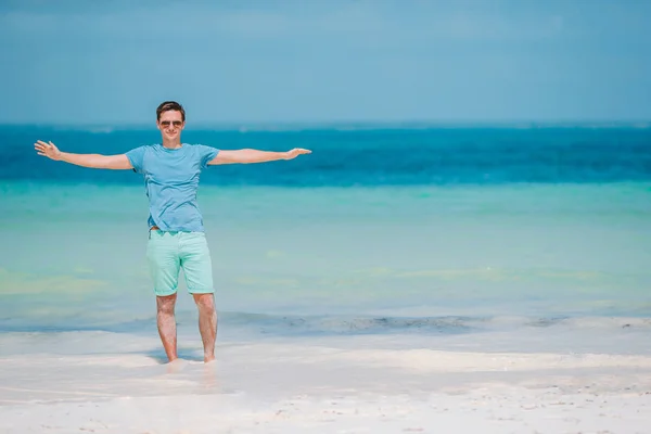 Ung man på den vita tropiska stranden — Stockfoto